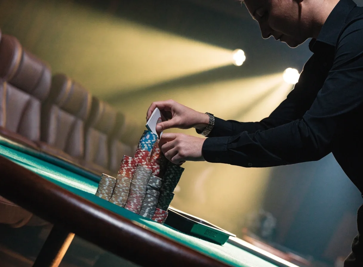 Karty i żetony na stole pokerowym w ciepłym świetle